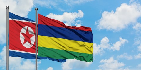 North Korea and Mauritius flag waving in the wind against white cloudy blue sky together. Diplomacy concept, international relations.