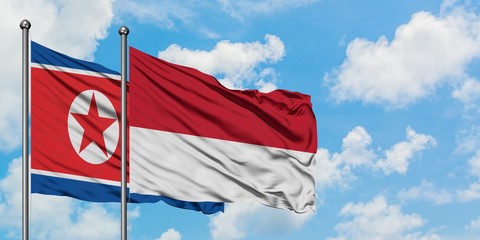 North Korea and Monaco flag waving in the wind against white cloudy blue sky together. Diplomacy concept, international relations.