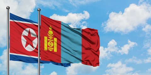 North Korea and Mongolia flag waving in the wind against white cloudy blue sky together. Diplomacy concept, international relations.