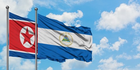 North Korea and Nicaragua flag waving in the wind against white cloudy blue sky together. Diplomacy concept, international relations.
