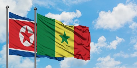 North Korea and Senegal flag waving in the wind against white cloudy blue sky together. Diplomacy concept, international relations.