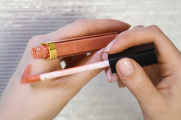 Woman's beauty blogger hands holding bottles and tubes spa professional hi-end cosmetics applies...