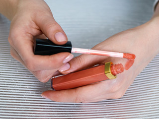 Woman's beauty blogger hands holding bottles and tubes spa professional hi-end cosmetics applies...