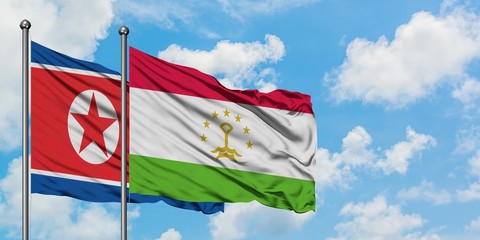 North Korea and Tajikistan flag waving in the wind against white cloudy blue sky together. Diplomacy concept, international relations.