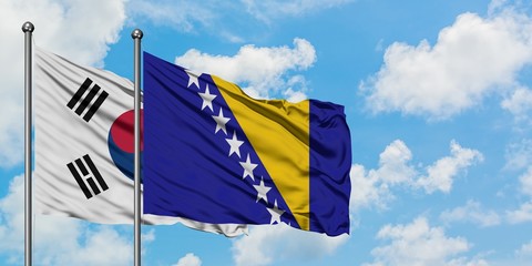South Korea and Bosnia Herzegovina flag waving in the wind against white cloudy blue sky together. Diplomacy concept, international relations.
