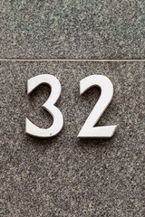 white number 32 on granite stone wall