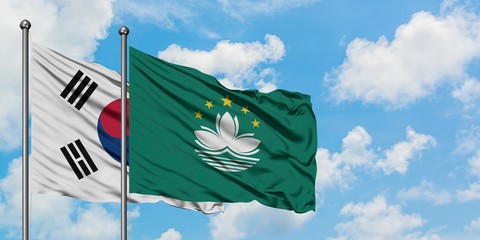 South Korea and Macao flag waving in the wind against white cloudy blue sky together. Diplomacy concept, international relations.