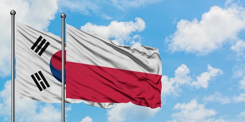 South Korea and Poland flag waving in the wind against white cloudy blue sky together. Diplomacy concept, international relations.