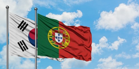 South Korea and Portugal flag waving in the wind against white cloudy blue sky together. Diplomacy concept, international relations.