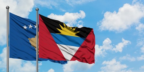 Kosovo and Antigua and Barbuda flag waving in the wind against white cloudy blue sky together. Diplomacy concept, international relations.