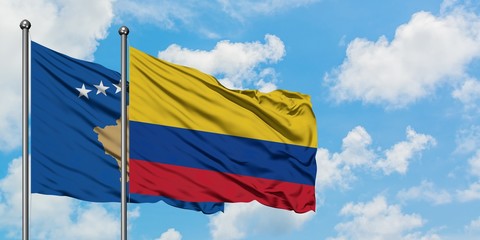 Kosovo and Colombia flag waving in the wind against white cloudy blue sky together. Diplomacy concept, international relations.