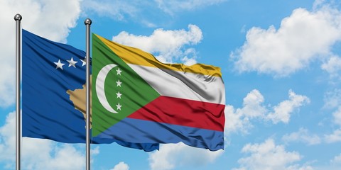 Kosovo and Comoros flag waving in the wind against white cloudy blue sky together. Diplomacy concept, international relations.