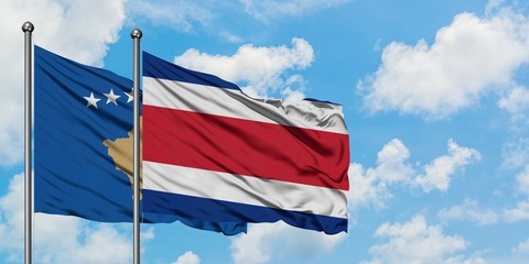 Kosovo and Costa Rica flag waving in the wind against white cloudy blue sky together. Diplomacy concept, international relations.