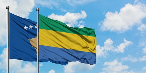 Kosovo and Gabon flag waving in the wind against white cloudy blue sky together. Diplomacy concept, international relations.