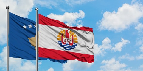Kosovo and French Polynesia flag waving in the wind against white cloudy blue sky together. Diplomacy concept, international relations.
