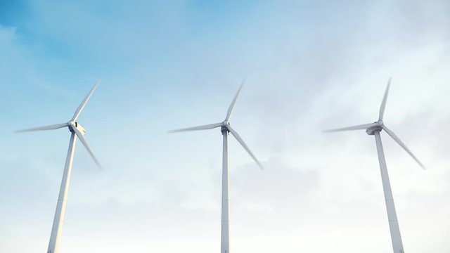 Wind turbines in the green field with cloudy sky in the background. Alternative renewable energy generation. Environmental conservation concept.
