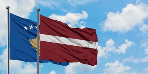Kosovo and Latvia flag waving in the wind against white cloudy blue sky together. Diplomacy concept, international relations.