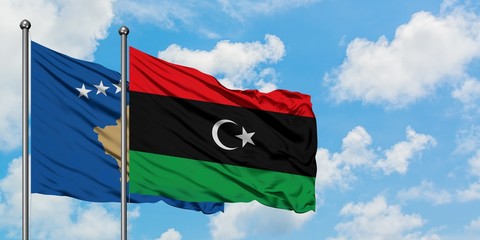 Kosovo and Libya flag waving in the wind against white cloudy blue sky together. Diplomacy concept, international relations.