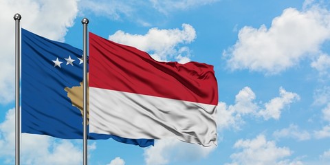 Kosovo and Monaco flag waving in the wind against white cloudy blue sky together. Diplomacy concept, international relations.