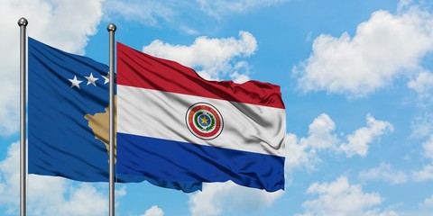 Kosovo and Paraguay flag waving in the wind against white cloudy blue sky together. Diplomacy concept, international relations.