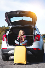 young  girl portrait at the car trunk