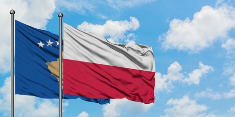 Kosovo and Poland flag waving in the wind against white cloudy blue sky together. Diplomacy concept, international relations.