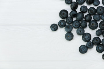 Blueberries on white wooden background. Healthy food. Place for label