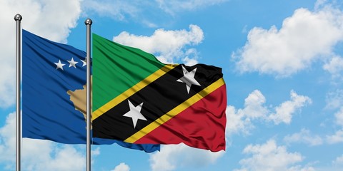Kosovo and Saint Kitts And Nevis flag waving in the wind against white cloudy blue sky together. Diplomacy concept, international relations.