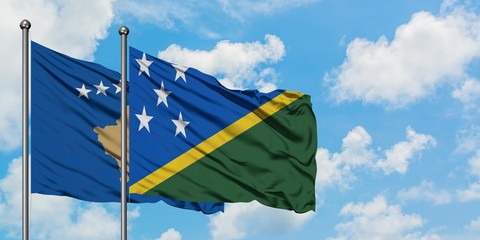 Kosovo and Solomon Islands flag waving in the wind against white cloudy blue sky together. Diplomacy concept, international relations.