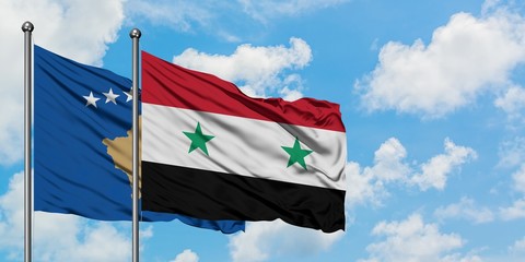 Kosovo and Syria flag waving in the wind against white cloudy blue sky together. Diplomacy concept, international relations.