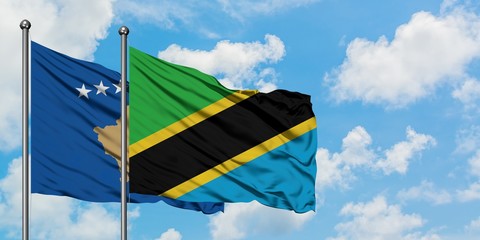Kosovo and Tanzania flag waving in the wind against white cloudy blue sky together. Diplomacy concept, international relations.