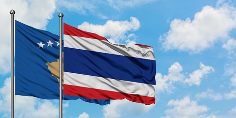 Kosovo and Thailand flag waving in the wind against white cloudy blue sky together. Diplomacy concept, international relations.