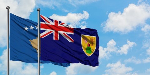 Kosovo and Turks And Caicos Islands flag waving in the wind against white cloudy blue sky together. Diplomacy concept, international relations.