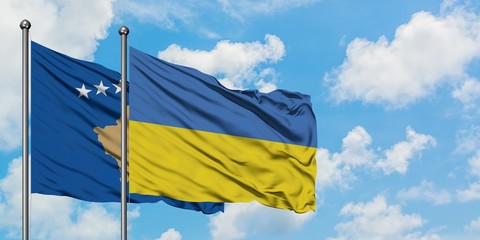 Kosovo and Ukraine flag waving in the wind against white cloudy blue sky together. Diplomacy concept, international relations.