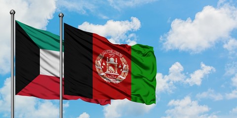 Kuwait and Afghanistan flag waving in the wind against white cloudy blue sky together. Diplomacy concept, international relations.