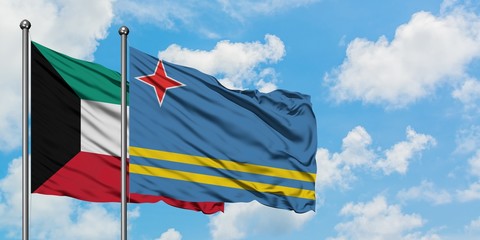 Kuwait and Aruba flag waving in the wind against white cloudy blue sky together. Diplomacy concept, international relations.