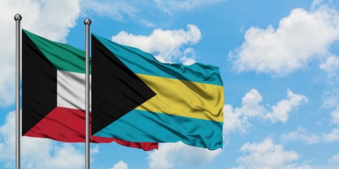 Kuwait and Bahamas flag waving in the wind against white cloudy blue sky together. Diplomacy concept, international relations.