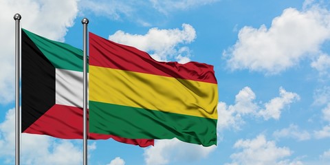 Kuwait and Bolivia flag waving in the wind against white cloudy blue sky together. Diplomacy concept, international relations.