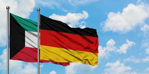 Kuwait and Germany flag waving in the wind against white cloudy blue sky together. Diplomacy concept, international relations.