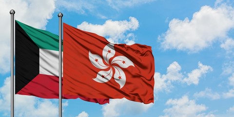 Kuwait and Hong Kong flag waving in the wind against white cloudy blue sky together. Diplomacy concept, international relations.