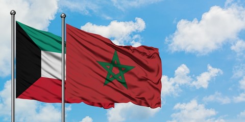 Kuwait and Morocco flag waving in the wind against white cloudy blue sky together. Diplomacy concept, international relations.