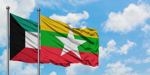 Kuwait and Myanmar flag waving in the wind against white cloudy blue sky together. Diplomacy concept, international relations.