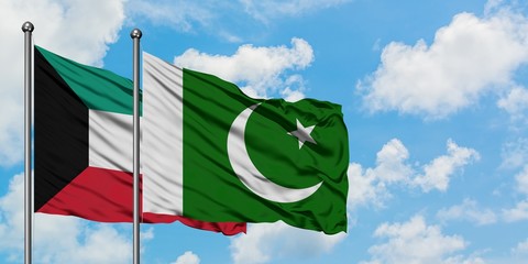 Kuwait and Pakistan flag waving in the wind against white cloudy blue sky together. Diplomacy concept, international relations.