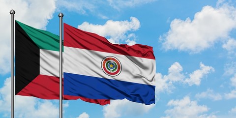 Kuwait and Paraguay flag waving in the wind against white cloudy blue sky together. Diplomacy concept, international relations.