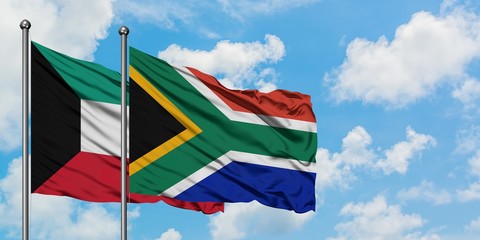 Kuwait and South Africa flag waving in the wind against white cloudy blue sky together. Diplomacy concept, international relations.