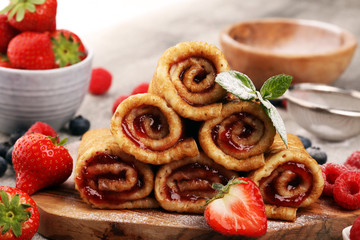 Delicious Tasty Homemade crepes or pancakes with raspberries and mint on rustic background