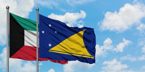Kuwait and Tokelau flag waving in the wind against white cloudy blue sky together. Diplomacy concept, international relations.