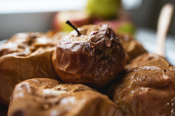Baked apples, sprinkled with cinnamon and honey in a ceramic dish
