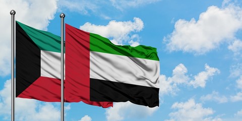 Kuwait and United Arab Emirates flag waving in the wind against white cloudy blue sky together. Diplomacy concept, international relations.