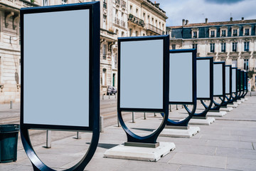 Line of clear billboards on city street with blank copy space screen for advertising or promotional...